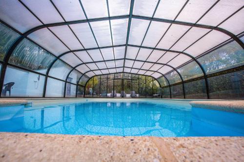La Chapelle-NeuveDomaine de Lann Kerhuerh的一个带玻璃天花板的室内游泳池