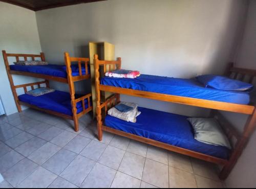 卡诺阿斯Hosthê compartilhados的客房设有三张双层床,配有蓝色床单
