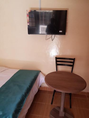 马查科斯Hakuna matata Airbnb的一张桌子和椅子,位于一个配有一张床和微波炉的房间