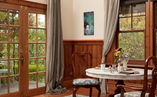 亚历山德拉Summerlands - Country Luxe的客房设有桌椅和窗户。