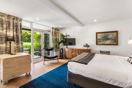 奥克兰Gorgeous Herne Bay Pied Terre - Auckland Central的一间卧室配有一张床、一张桌子和一把椅子