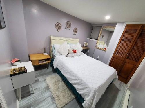 University HeightsLovely 2 bedroom unit in private home的一间卧室配有带白色床单和枕头的床。