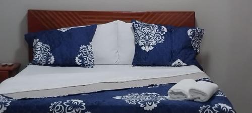 伊基托斯La casita Azul - Río Mar - Iquitos的一张带蓝色和白色床单及蓝色枕头的床