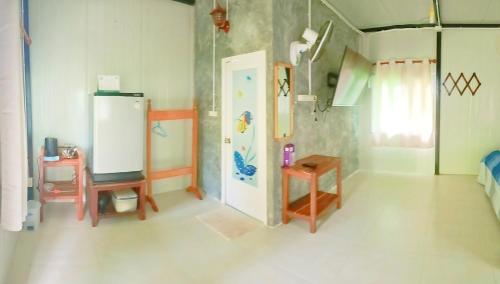 Ban Bang BaoLung peiyk homestay的一间配备有冰箱和桌子的客房