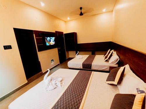 拉米斯瓦拉姆HOTEL ELITE的客房设有两张床和一台平面电视。