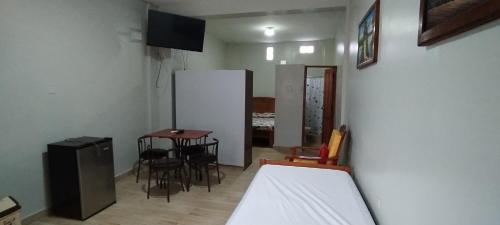 伊基托斯Mini Departamento Iquitos 1243的配有一张床和一张桌子及椅子的房间
