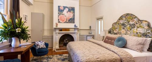 亚历山德拉Summerlands - Country Luxe的客厅设有一张床和一个壁炉