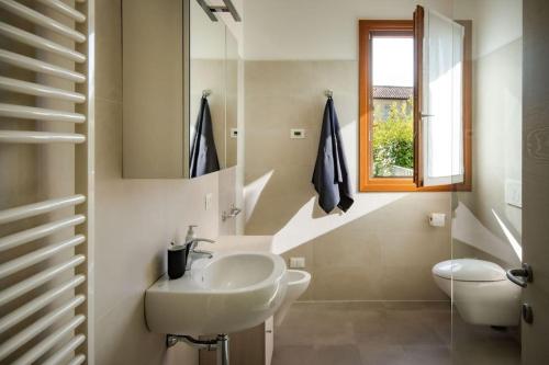 Cappella MaggioreAppartamento Cansiglio的白色的浴室设有水槽和窗户。