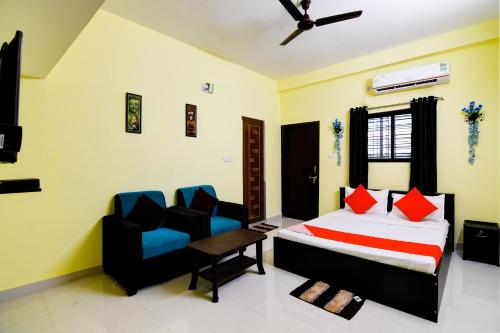 布巴内什瓦尔OYO Flagship Sri Balaji Guest House的一间卧室配有一张床和两把椅子