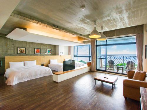 鹅銮鼻垦丁泊途会馆的一间带两张床的卧室,享有海景