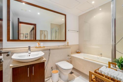 迪拜Boutique Apartment Sea Views - Dubai Marina的浴室配有盥洗盆、卫生间和浴缸。