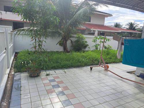 民都鲁Bintulu AirBnB Homestay的房屋前设有铺着瓷砖地板的庭院。