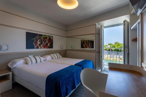 蒙达卡Hotel&Spa El Puerto的酒店客房设有两张床和一个阳台。