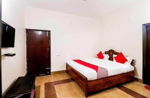 布巴内什瓦尔OYO Flagship 64921 Purple Villa的一间卧室配有红色和白色枕头的床