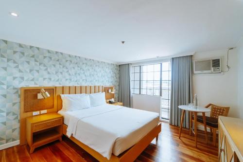 巴科洛德Sugarland Hotel的酒店客房配有一张床铺和一张桌子。