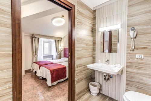 罗马米洛酒店的浴室设有床、水槽和镜子