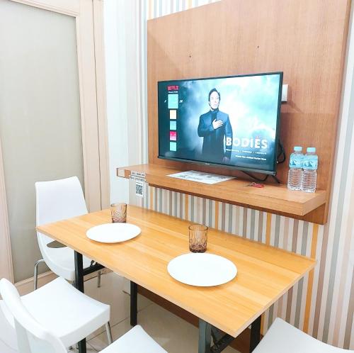马尼拉Sea Residences by Jan & Val Alano的配有电视和桌椅的房间