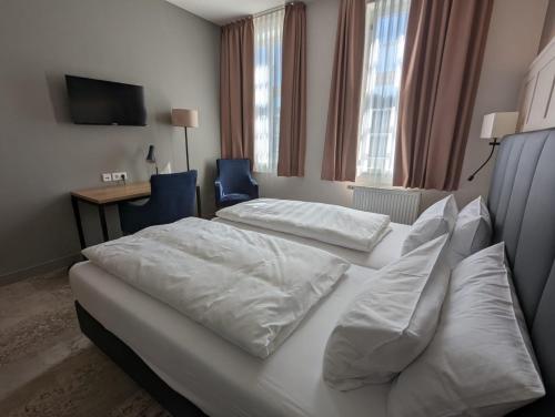 比丁根Hotel Fürstenhof的酒店客房配有两张床和一张书桌