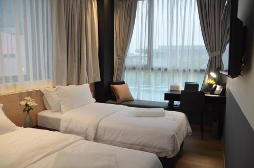 新加坡VicHaus Serviced Apartment的酒店客房配有两张床和一张书桌