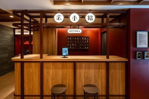 东京Section L Ueno-Hirokoji的餐厅里的一个酒吧,周围摆放着三把椅子