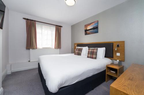 马奇叶奥尔德格里芬酒店 的卧室设有一张白色大床和一扇窗户。