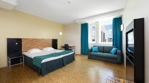 塔林Hestia Hotel Seaport Tallinn的酒店客房,配有床和沙发