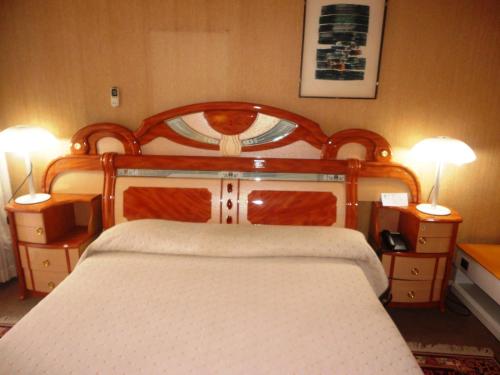 布琼布拉Hôtel Source Du Nil的一间卧室配有木床和2个床头柜