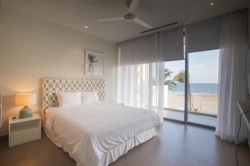 后川Faru Beachfront Villa Sanctuary Ho Tram的一间卧室配有一张床,享有海滩美景