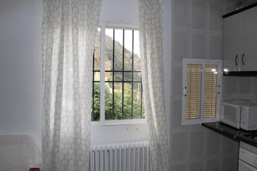 卡索拉Casa La Azotea de Cazorla的白色的厨房,配有窗户和散热器