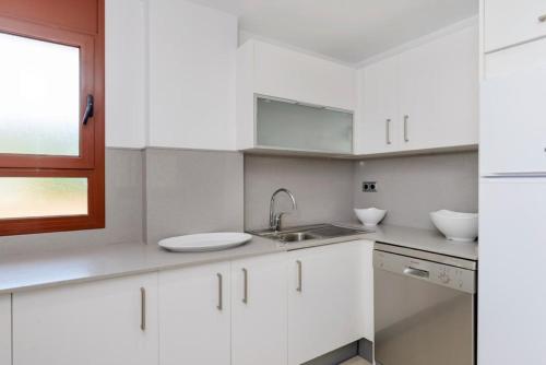 滨海托萨Tossa dreams的白色的厨房设有水槽和窗户