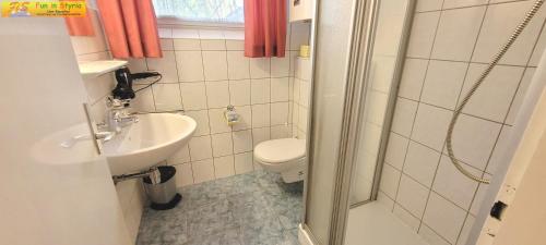 巴德米滕多夫Bungalow Irmgard by FiS - Fun in Styria的浴室配有卫生间、盥洗盆和淋浴。