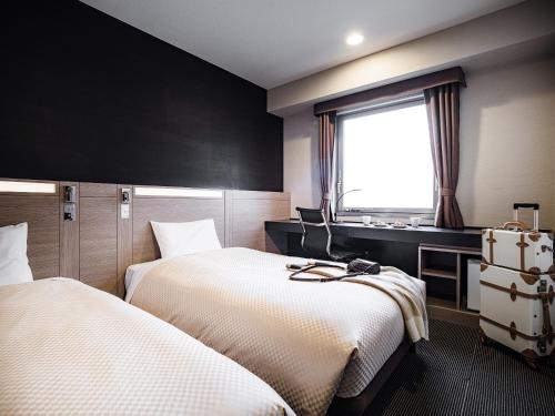 冈山冈山三井花园酒店 的酒店客房设有两张床和窗户。