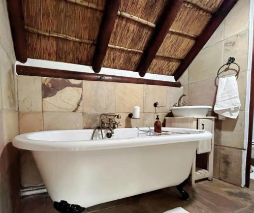 乔治Prospect Farm Cottages的一个带水槽的浴室内的白色大浴缸