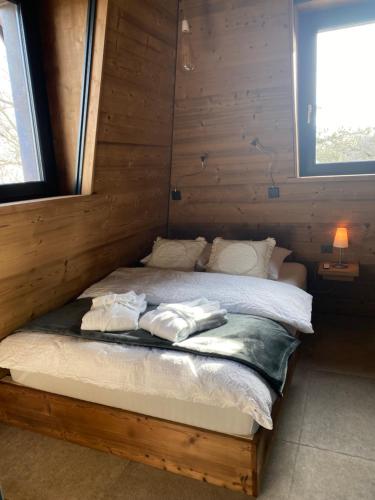 Les Hauts-GeneveysLe Manoir de l'Oselière & Spa的小木屋内的一张床位,上面有两条毛巾