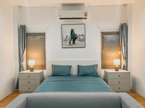 拉威海滩Rawai Valley Resort的一间卧室配有蓝色的床和2个床头柜