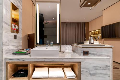 佛山宜尚Plus酒店--佛山智慧新城张槎地铁站店的浴室配有盥洗盆和带毛巾的台面。