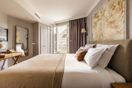 巴黎Maison Pigalle的一间卧室设有一张大床和窗户