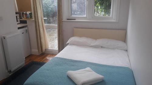 伦敦Luxury studio flat的一间卧室配有一张床,上面有两条毛巾