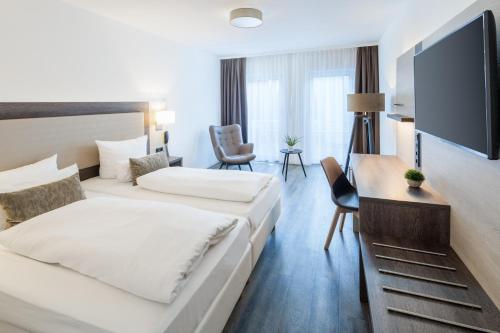 莱茵河畔路德维希港Hotel Newton Ludwigshafen的酒店客房设有两张床和一台平面电视。
