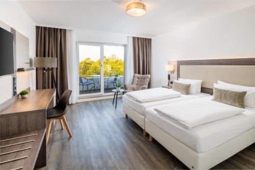 莱茵河畔路德维希港Hotel Newton Ludwigshafen的酒店客房配有两张床和一张书桌