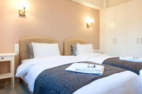 雅典Sunlit Apartment with Acropolis View的宿舍间的两张床,床上有浴袍