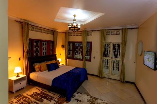 坎帕拉The Mbuya Residence的一间卧室配有一张特大号床和两个窗户
