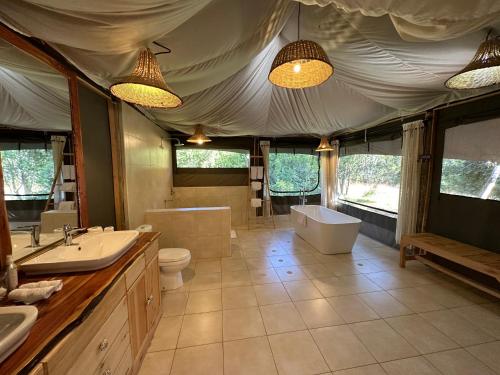 纳纽基Ole Samara guest suites的带浴缸、卫生间和盥洗盆的浴室