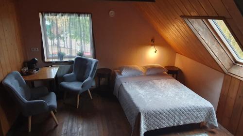 KoloreinoKütioru puhkekeskus的一间卧室配有一张床、一张桌子和两把椅子