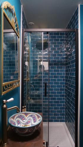 加来Spa Le Rubis d'Orient的浴室设有水槽和蓝色瓷砖淋浴。