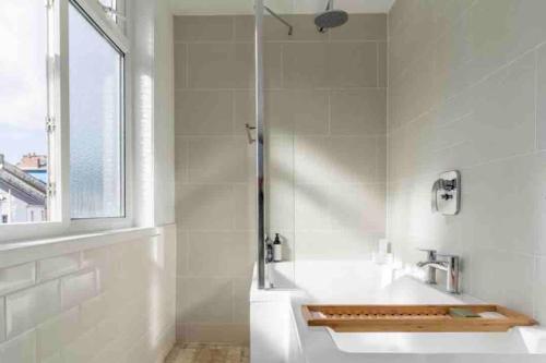 法尔茅斯Harbour Strand的白色的浴室设有水槽和窗户。