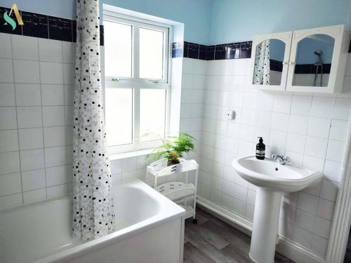 蒂斯河畔斯托克顿St Bernard House TSAC的白色的浴室设有水槽、浴缸和水槽。