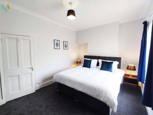 蒂斯河畔斯托克顿St Bernard House TSAC的卧室配有带蓝色枕头的大型白色床