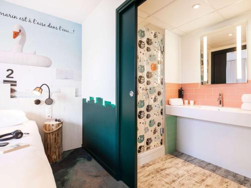 托农莱班ibis Styles Thonon-les-Bains的浴室设有绿门和水槽