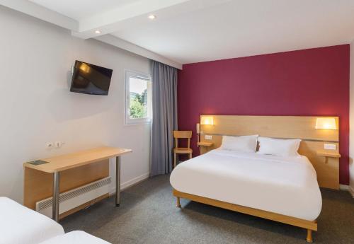 Vals-près-le-PuyB&B HOTEL Le Puy-en-Velay的配有一张床和一张书桌的酒店客房